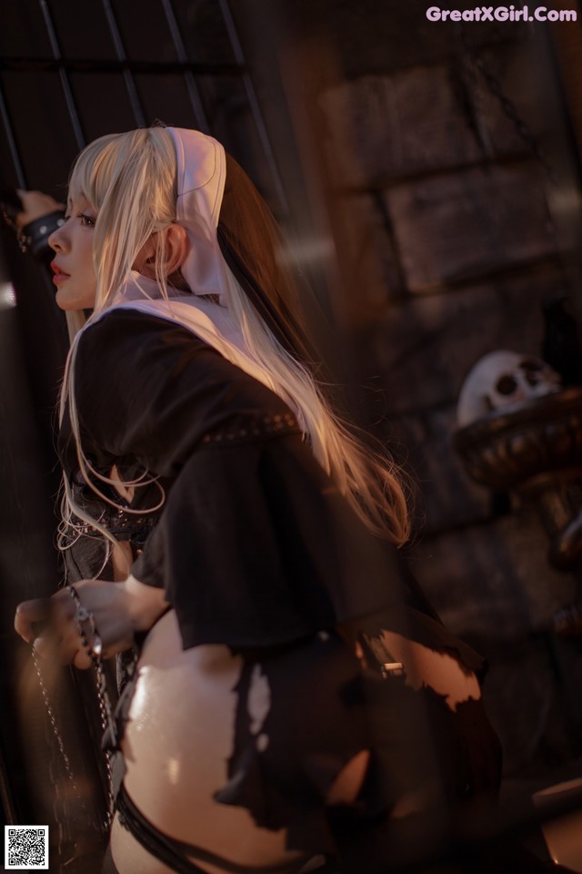 A woman dressed as a nun holding a chain.