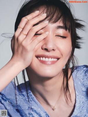 A woman in a white dress posing for a magazine.