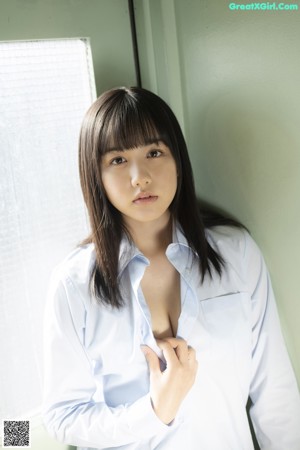 A young woman in a school uniform posing for a picture.