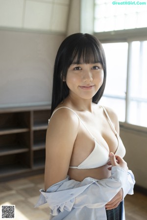 A woman in a white bra top and a green plaid skirt.
