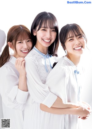 A group of three women sitting on the ground.