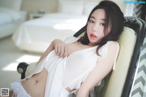 A woman in a white dress taking a selfie.
