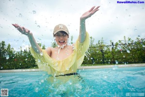 A young woman in a swimming pool with her eyes closed.