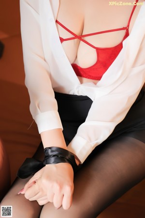 A woman in a white shirt and black skirt posing for a picture.