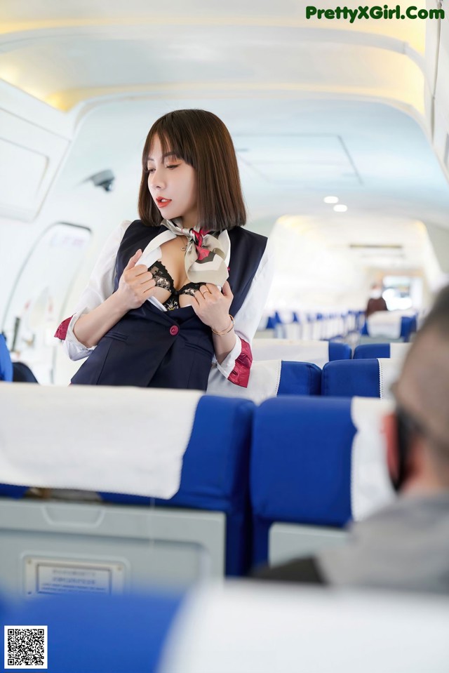 A woman in a business suit is sitting in an airplane.