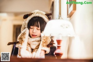 A girl in a dress holding a teddy bear on a sidewalk.