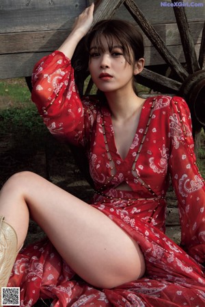 A woman sitting on the ground with her legs crossed.