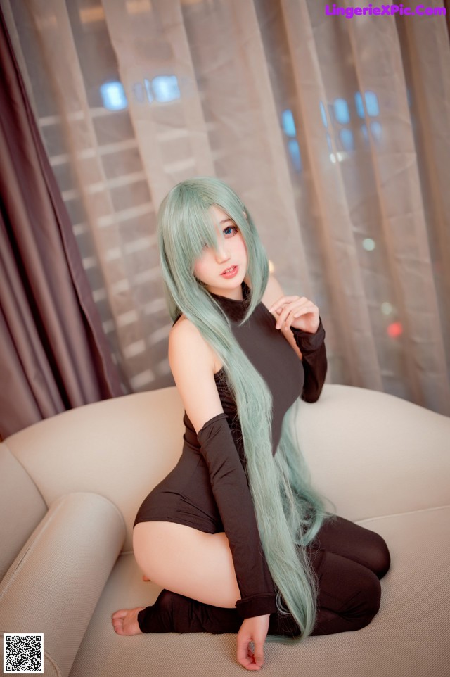 A woman with long green hair sitting on a couch.