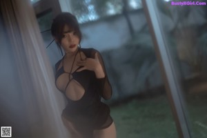 A woman in a black dress leaning against a wall.