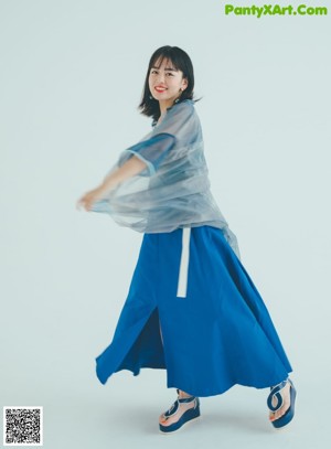 A woman in a long dress standing on a set of stairs.