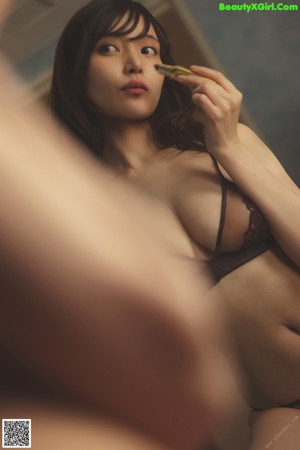 A woman in a black lingerie standing in a shower.
