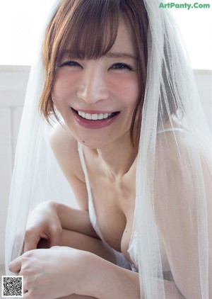 A woman leaning against a wall with her back to the camera.