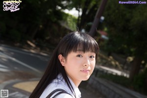 A young woman wearing a white shirt and a blue bow tie.