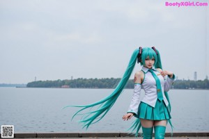 A girl with green hair wearing headphones and a tie.
