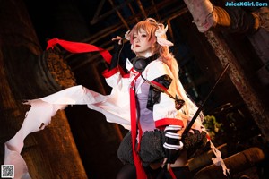 A woman dressed as a demon sitting on the ground.