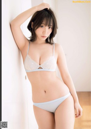 A woman in a white and yellow bikini posing for a picture.