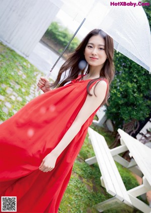 A woman in a blue polka dot dress posing for a magazine.